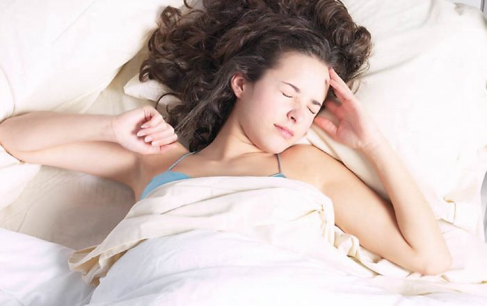 Young woman waking to bright sunlight